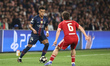 Desire Doue of Paris Saint-Germain holds the ball as Milos Kerkez of Liverpool applies pre...