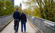A couple walks hand in hand along a park path in Speyer, Rhineland-Palatinate, Germany, on...
