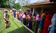 Voters stand in queues to cast their ballots at a polling booth during the Assam Legislati...