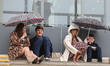 Racegoers evade the rain as it starts to pour ahead of the first race during the 2026 Rand...