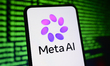 The new Meta AI logo is displayed on a smartphone screen with lines of computer code in th...