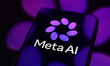 The new Meta AI logo is displayed on a smartphone screen placed on a reflective surface on...