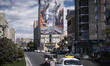 Vehicles drive beneath a giant billboard displaying an AI-generated image in downtown Tehr...