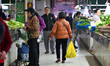 Customers purchase vegetables at a farmer's market in Nanjing, Jiangsu Province, China, on...