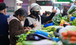 Customers purchase vegetables at a farmer's market in Nanjing, Jiangsu Province, China, on...