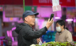 Customers purchase vegetables at a farmer's market in Nanjing, Jiangsu Province, China, on...