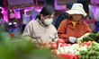 Customers purchase vegetables at a farmer's market in Nanjing, Jiangsu Province, China, on...