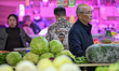 Customers purchase vegetables at a farmer's market in Nanjing, Jiangsu Province, China, on...