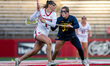 Kate Theofield of the Rutgers Scarlet Knights drives the ball against Emma Arico of the Mi...