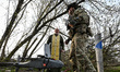 A soldier prepares a drone for launch in the presence of military chaplain Father Stepan i...
