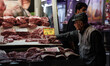 A customer selects meat to purchase at the Varvakios Central Municipal Market as demand ri...