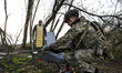 A soldier prepares a drone for launch in the presence of military chaplain Father Stepan i...