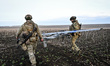 Soldiers carry a drone that was blessed by military chaplain Father Stepan before launch i...
