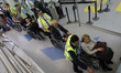Workers at Mexico City International Airport assist people with disabilities in wheelchair...