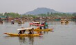 Men row their boats on the waters of Dal Lake in Srinagar, Jammu and Kashmir, on April 11,...
