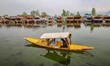 A man rows a boat on the waters of Dal Lake in Srinagar, Jammu and Kashmir, on April 11, 2...