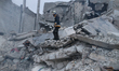 Civil defense teams attempt to rescue civilians trapped under the rubble after a powerful...