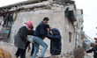Civil defense teams attempt to rescue civilians trapped under the rubble after a powerful...