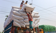 Workers load heavy sacks of chilies onto a truck at a factory in Bogura, Bangladesh, on Sa...