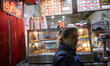 A young Iranian woman stands outside a small fast-food restaurant in downtown Tehran, Iran...