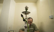 An Iranian man puffs on a hookah while sitting at a teahouse in downtown Tehran, Iran, on...