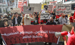 Demonstrators display a large banner in Arabic reading, ''Our crime is solidarity; yours i...