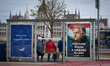 Two campaign posters are displayed at a public transport stop on the Buda bank of the Danu...
