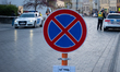 Police officers and police vehicles enforce temporary traffic and parking restrictions in...