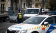 A police officer directs traffic beside a police vehicle near Heroes' Square (Hosok tere)...