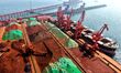 A cargo ship unloads imported iron ore at the Qingdao Port Ore Terminal in Shandong, China...