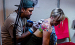 A tattoo artist tattoos a customer during the 13th International Nepal Tattoo Convention i...