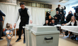 A man with a small child places his ballot in Budapest, Hungary on 12 April, 2026. 