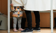A small child stands next to a voter in a booth in the 12th district in Budapest, Hungary...