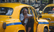 A yellow taxi driver waits for passengers outside a metro station in Kolkata, India, on Ap...