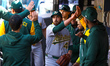 Athletics starting pitcher Aaron Civale #45 is congratulated in the dugout during the sixt...
