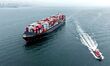 A cargo ship loaded with foreign trade containers sails towards Qingdao Port along Jiaozho...