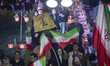 Pro-government supporters wave national flags and a flag of Lebanon's Hezbollah while part...