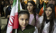 A young pro-government supporter holds a national flag during a state-run program related...
