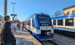 Passengers board and wait beside a Bayerische Regiobahn train at Schliersee station in Sch...