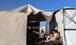 A displaced Palestinian girl reads in front of her family's tent inside Gaza's port on Apr...