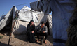 Displaced Palestinians drink tea in front of their tent inside Gaza City's port on April 1...
