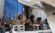 Palestinian students attend lessons in a temporary school in Jabalia refugee camp in the n...