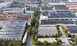 Construction workers install photovoltaic modules on the roof of the factory building of J...