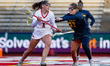 Kate Theofield of the Rutgers Scarlet Knights drives the ball against Emma Arico of the Mi...