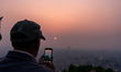 People watch and photograph the first rising sun of the Nepali calendar year 2083 from Swa...
