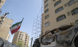 An Iranian flag is placed next to a vehicle destroyed in a U.S.-Israeli military operation...