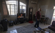 An Iranian resident walks through his damaged apartment in the Shahid Boroujerdi residenti...
