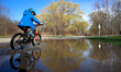 A cyclist rides through water on a flooded footpath beside the Etobicoke Creek in downtown...