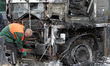 A worker stands by a burnt-out truck after a missile strike in Dnipro, Ukraine, on April 1...