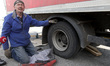 Driver Oleksandr speaks to the press as he replaces a tire of a Nova Poshta truck damaged...